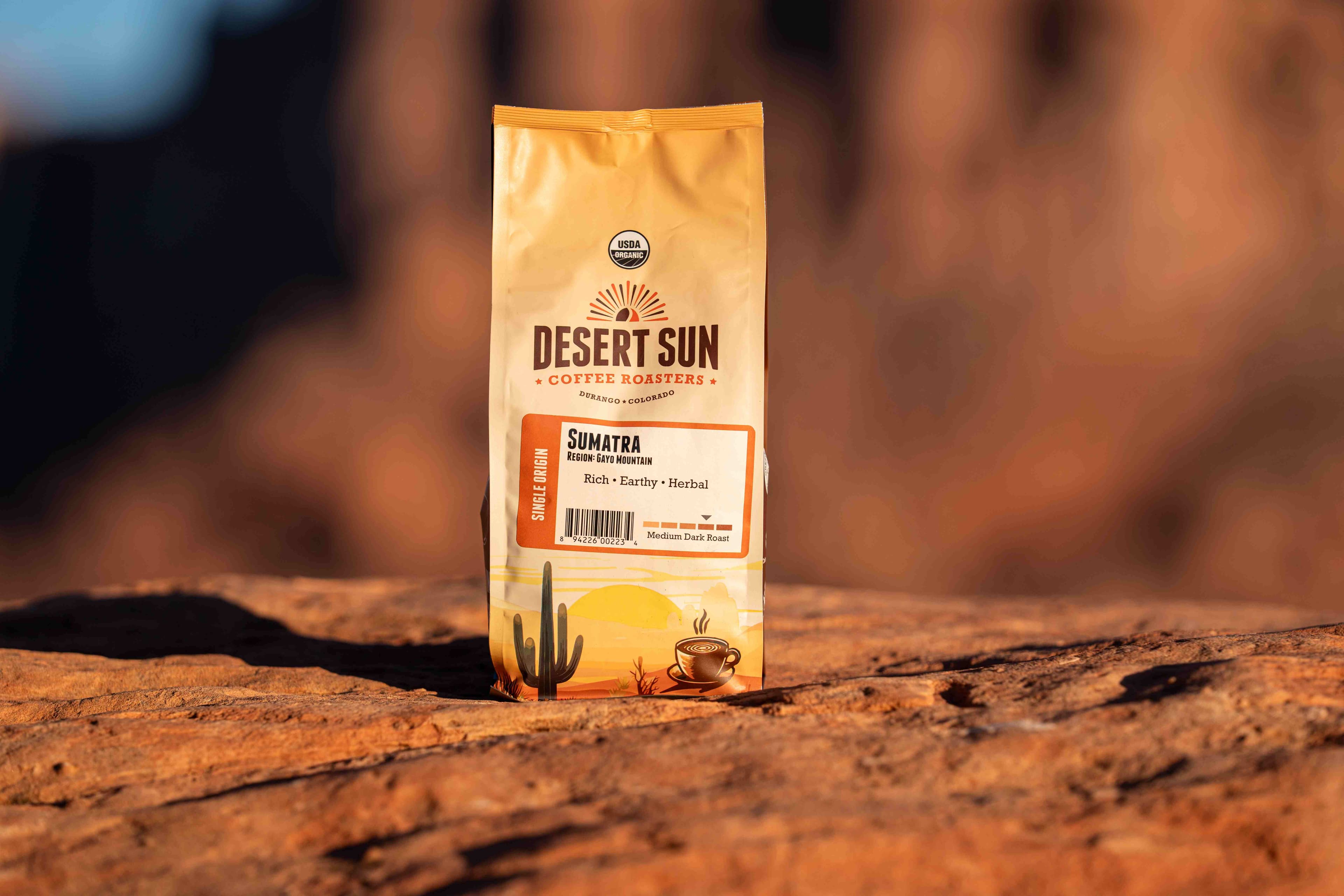 A bag of Desert Sun Sumatra standing on red sandstone at first light, the cliffs of the Valley of the Gods soft behind it