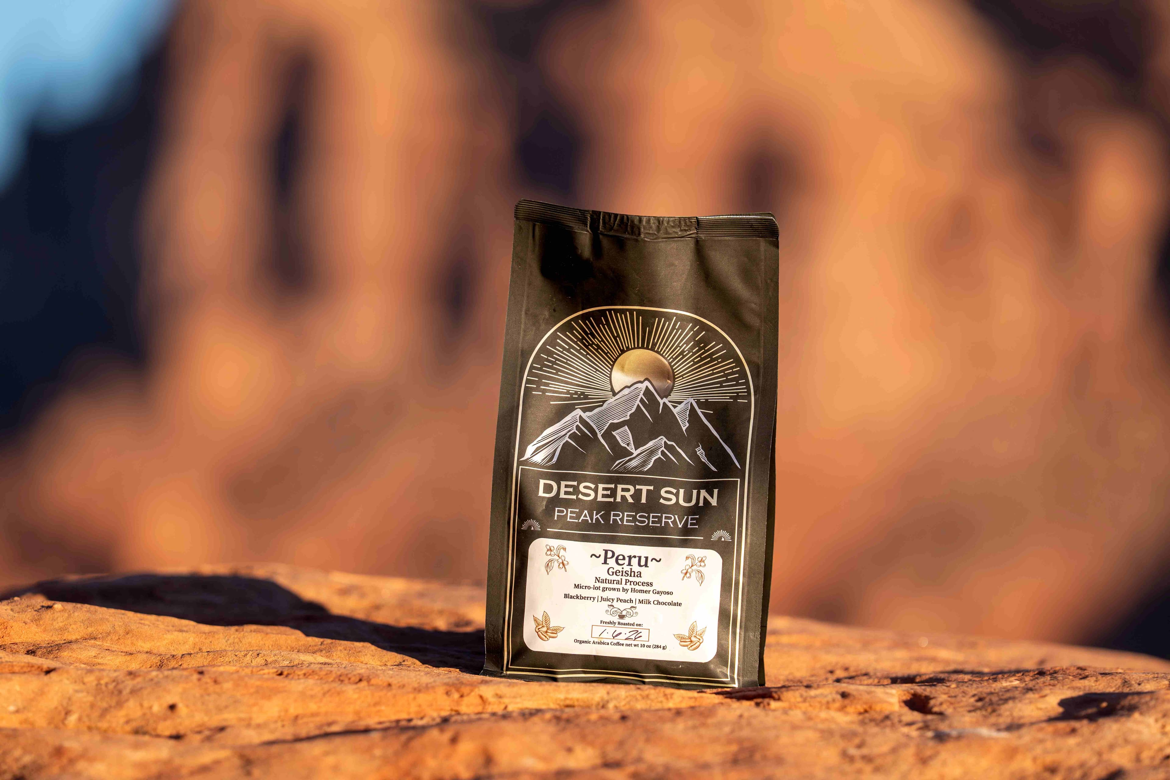 A black bag of Desert Sun Peak Reserve on red rock, the cliffs glowing orange behind it