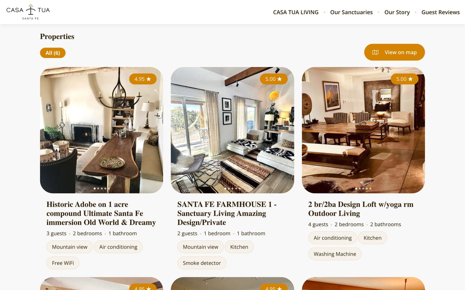 The old site's property list: three cards with star ratings of 4.95 and 5.00, Airbnb-style titles like Historic Adobe on 1 acre compound Ultimate Santa Fe immersion Old World & Dreamy, and amenity tags