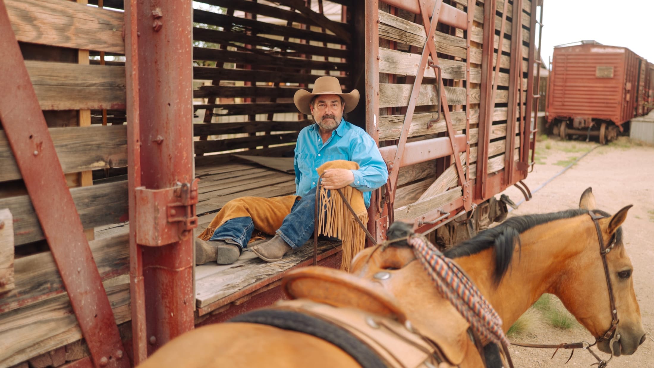 Clint Mortenson coiling rope in an antique stock railcar at the 6666 Ranch