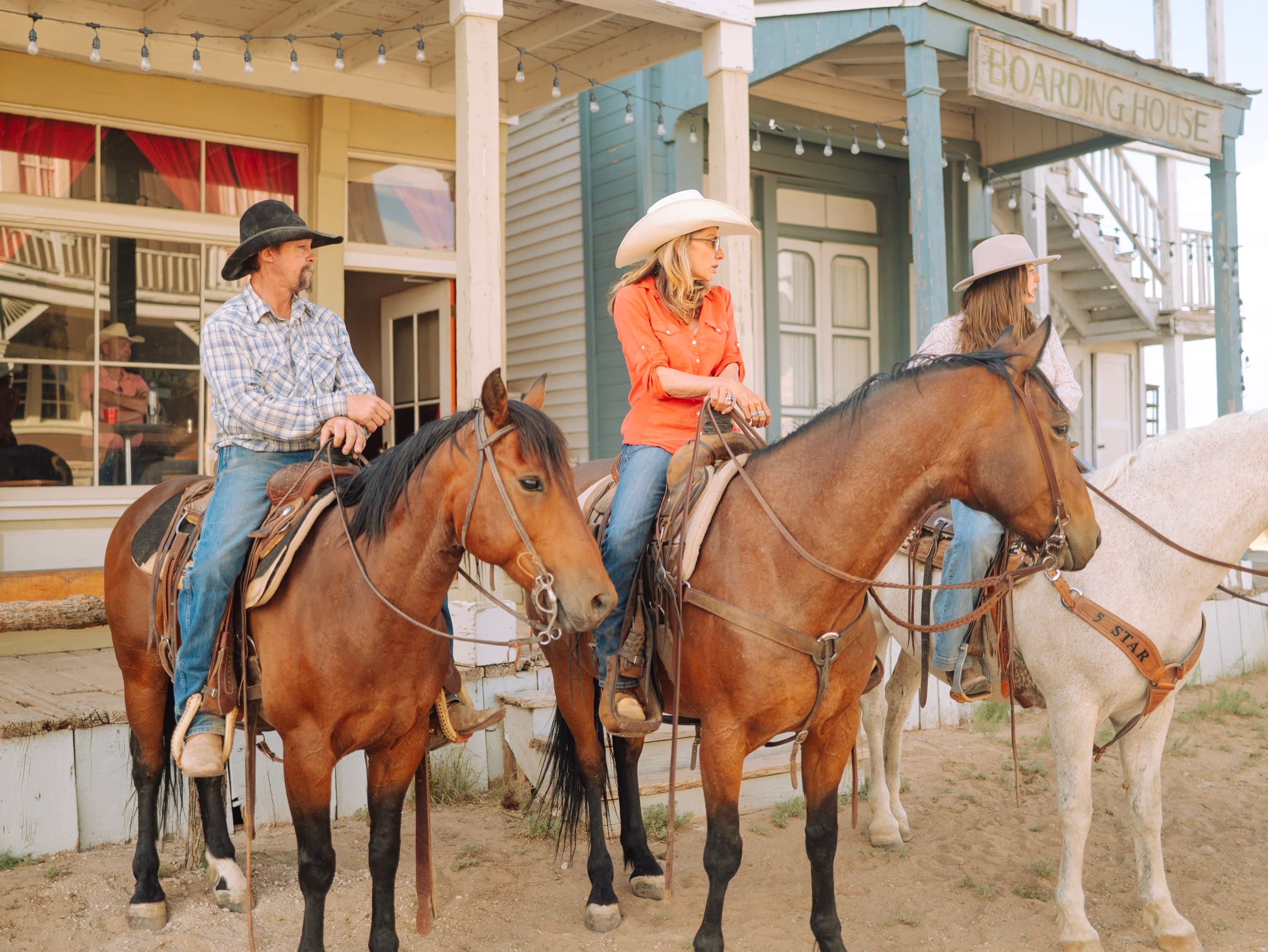 Riders gathered at the ranch's boarding house under warm string lights during a Creative Flow shoot