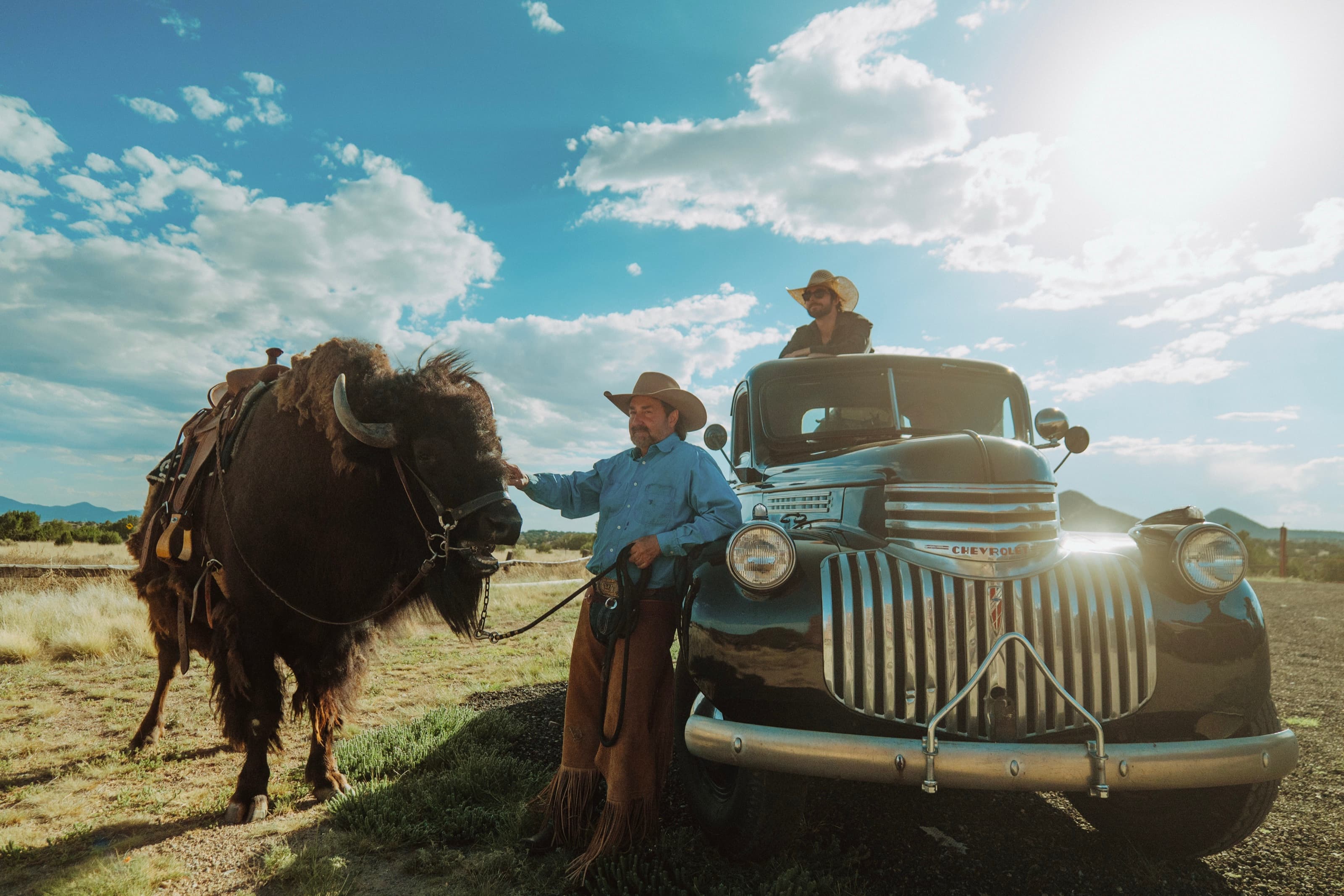 Clint Mortenson with Clyde the buffalo and a vintage truck at the 6666 Ranch