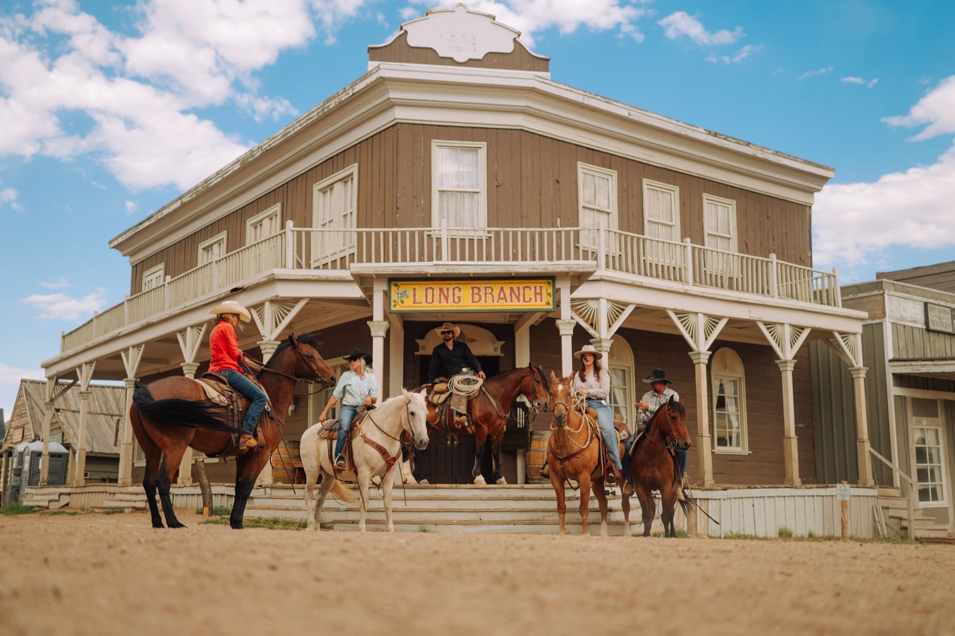 Riders posed in front of the Long Branch saloon on the 6666 Ranch's western set