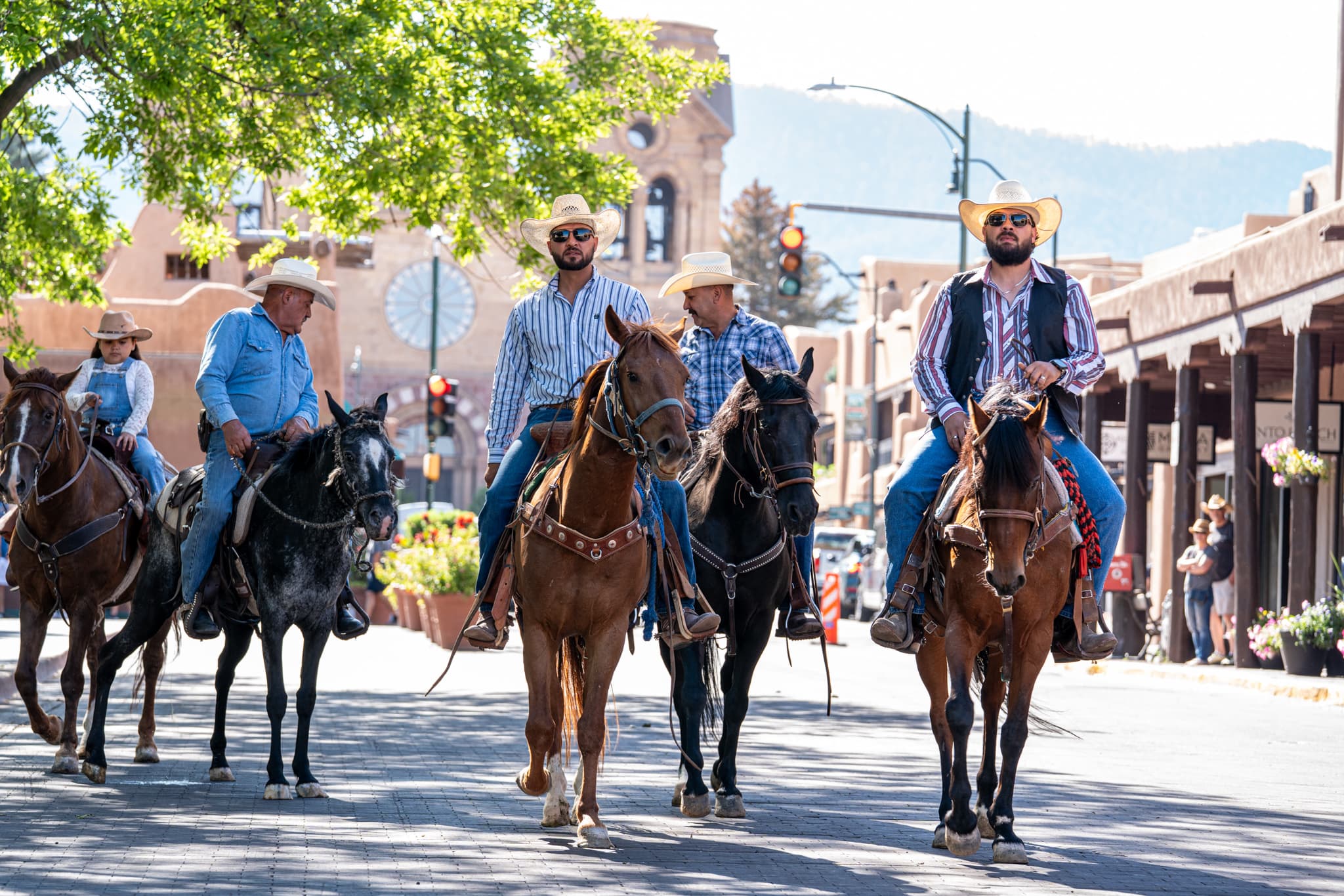 Reins Western Goods riders on horseback coming down a Santa Fe street